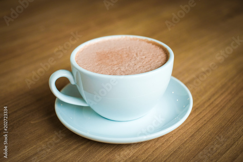 Cup of hot coffee (cappuccino or latte) decorated with milk forth on the surface serve on plate for beverage background - healthy diet concept.