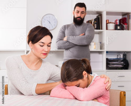 Father lecturing wife and daughter