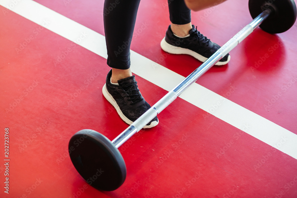 Φωτογραφία close up woman foots at gym with barbells on floor