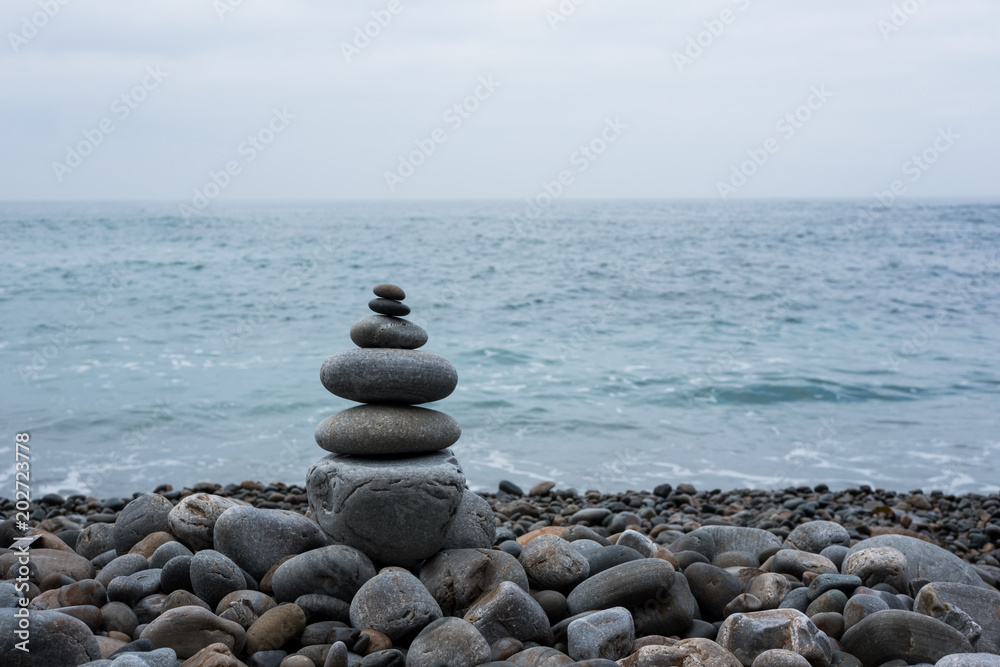 Naklejka Stos kamieni na plaży, morza i nieba