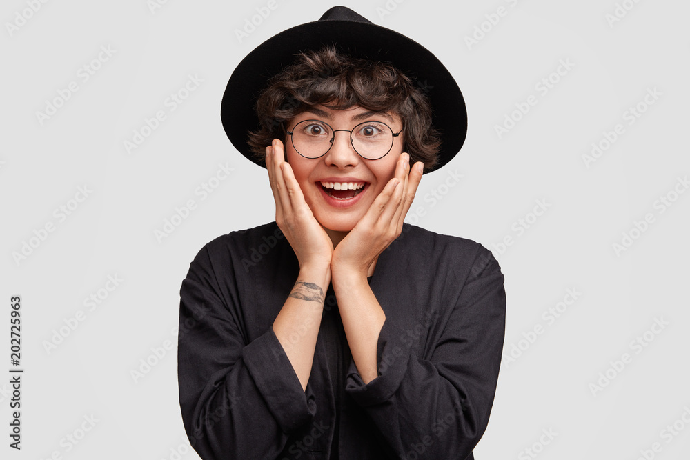 Happy overjoyed female student in black cloak and hat, rejoices getting diploma and graduating from university or college, has positive smile. Lovely glad young teacher recieves good words from pupil Happy overjoyed female student in black cloak and hat, rejoices getting diploma and graduating from university or college, has positive smile. Lovely glad young teacher recieves good words from pupil
