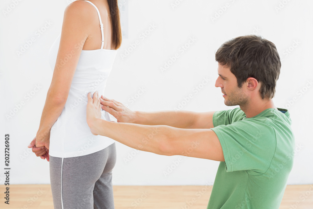 Obraz premium Physiotherapist examining womans back in medical office