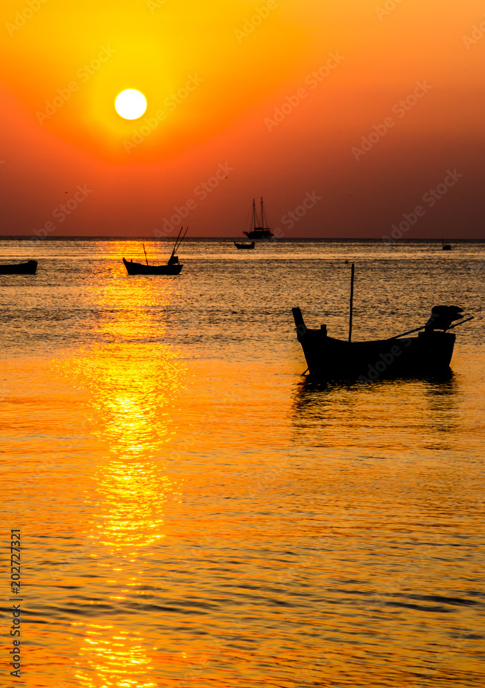 Blurred of silhouette boat on the ocean and sunset background