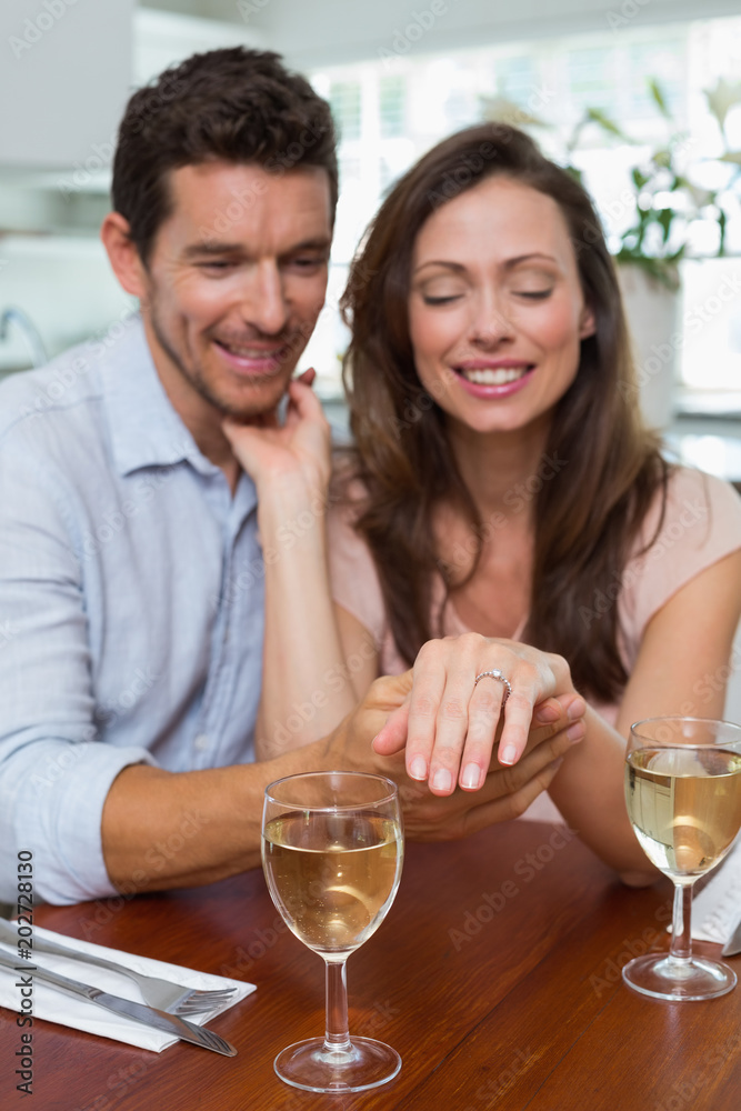 Happy woman showing engagement ring besides man Happy woman showing engagement ring besides man