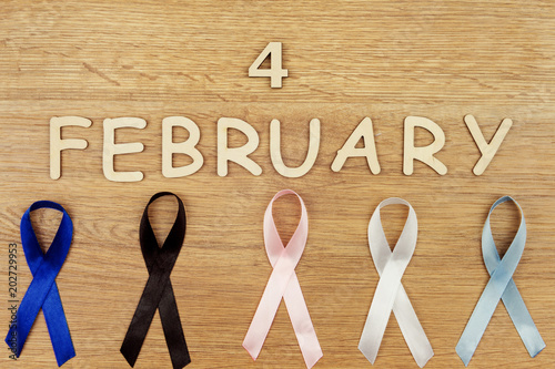 Date of world cancer day - 4 of fabruary together with blue ribbon bowel cancer, black ribbon melanoma, pink ribbon for breast cancer, white ribbon as a symbol of lung cancer, cyan -  prostate cancer photo