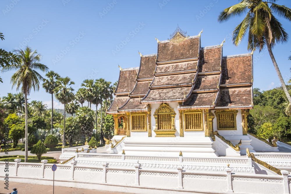 View of the temple in a blur background of surrounding trees in the  courtyard of the Grand Palace of Luang Prabang in Laos Stock Photo | Adobe  Stock