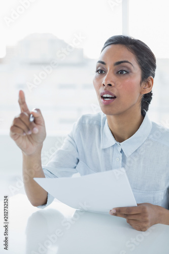 Classy businesswoman sitting at her desk photo