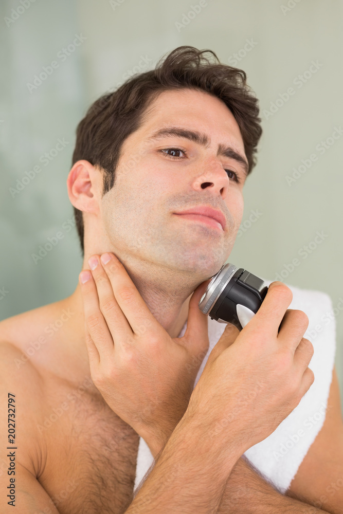 Handsome shirtless man shaving with electric razor Handsome shirtless man shaving with electric razor