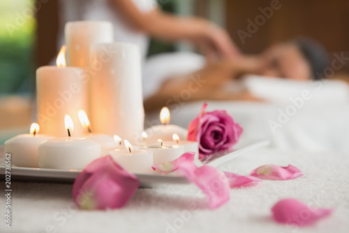 Candles and rose petals on massage table
