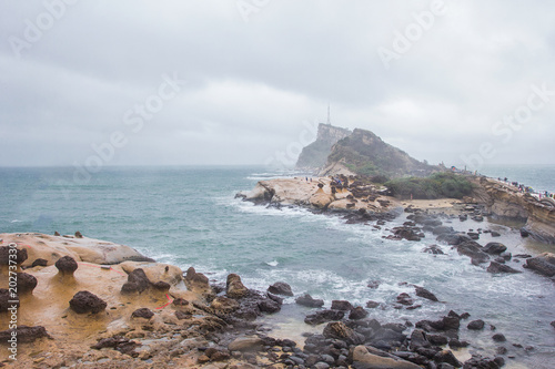 YEHLIU, TAIWAN - OCT11, 2016: Tourists at the Yeliu (Yehliu) Geopark in Wanli District, New Taipei, Taiwan at a rainy, windy and overcast day.