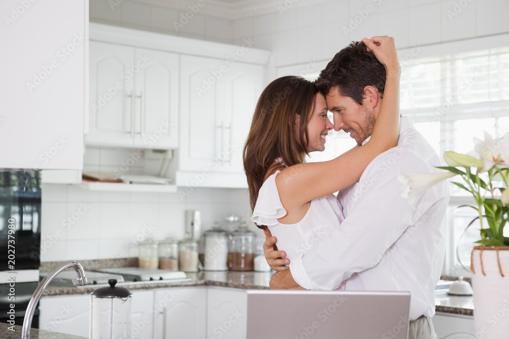 Loving couple looking at each other in kitchen Loving couple looking at each other in kitchen