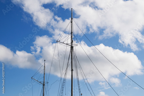 Masts of a sailing ship on blue sky background