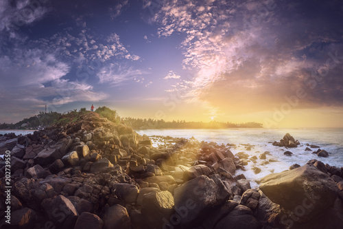 Tropical beach with rocks on sand coast of ocean