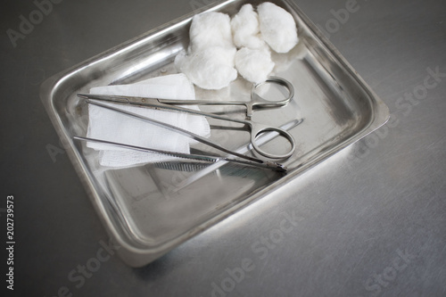 Gauze, Orthopedic Bandage,Cotton Swab, Tissue Forceps and Scissors on the Medical Stainless Steel Tray for Wound Dressing on the medical table photo