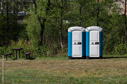 Two public toilets stand in the park