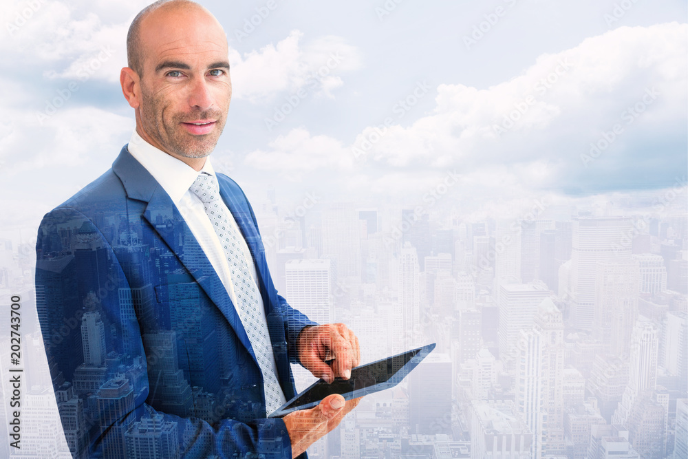 businessman using a tablet and smiling at the camera  against new york