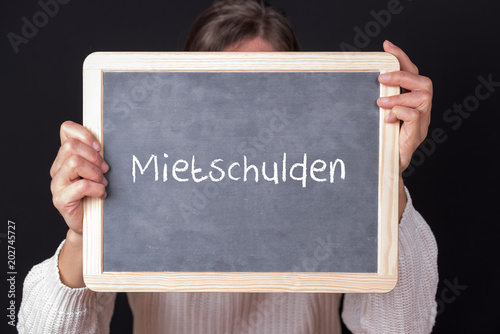 Frau mit einem Schild Mietschulden photo