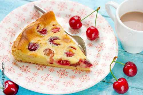 Slice of delicious pie with cherries and cream filling on plate for dessert photo