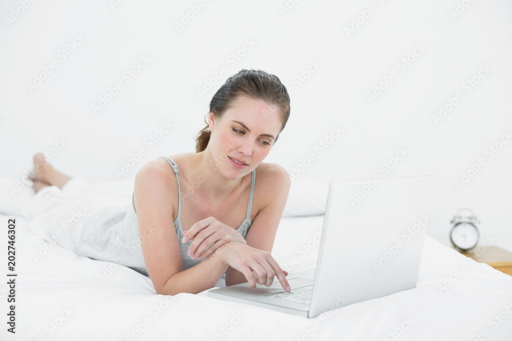 Casual woman using laptop in bed Casual woman using laptop in bed