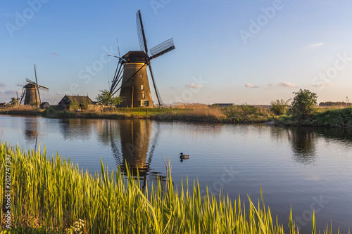Sunset on windmill reflected in the canal Kinderdijk Molenwaard South Holland The Netherlands Europe