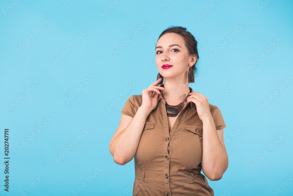 Confident girl smiling to camera. Portrait of woman over blue background