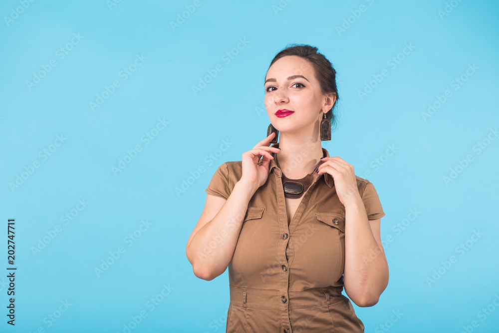 Confident girl smiling to camera. Portrait of woman over blue background Confident girl smiling to camera. Portrait of woman over blue background