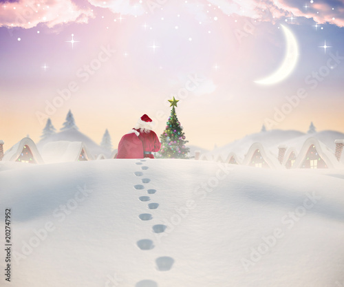 Santa walking in the snow against cute christmas village with tree