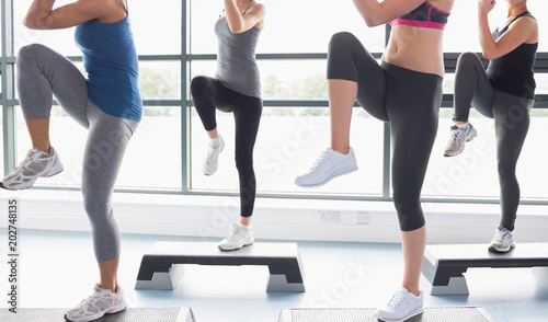 Women raising their legs while doing aerobics