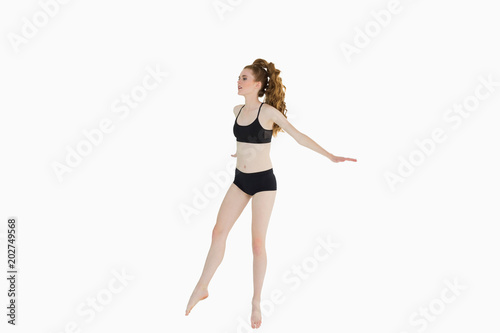 Fototapeta Naklejka Na Ścianę i Meble -  Full length of a sporty young woman stretching