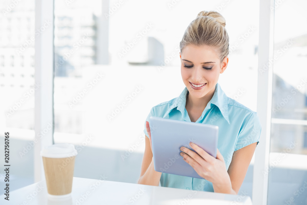 Smiling classy woman using tablet while having a break Smiling classy woman using tablet while having a break