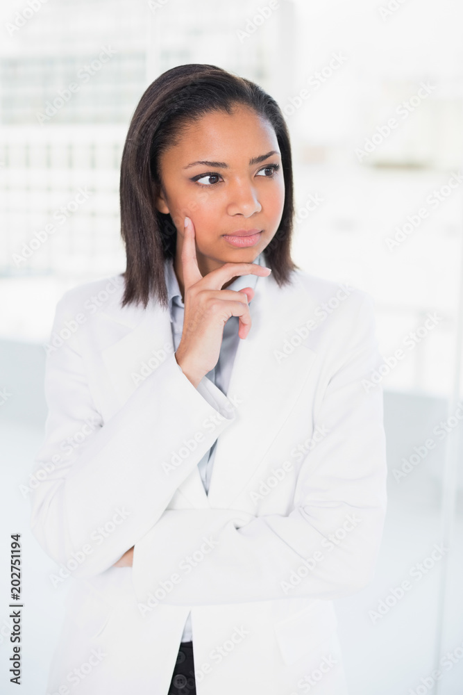 Thoughtful young dark haired businesswoman posing looking away Thoughtful young dark haired businesswoman posing looking away