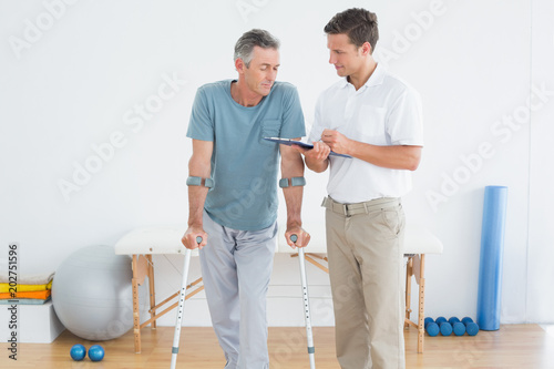 Therapist discussing reports with a disabled patient