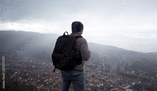 Hiker with backpack above the city