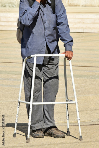 Homeless man on the street with a walker photo