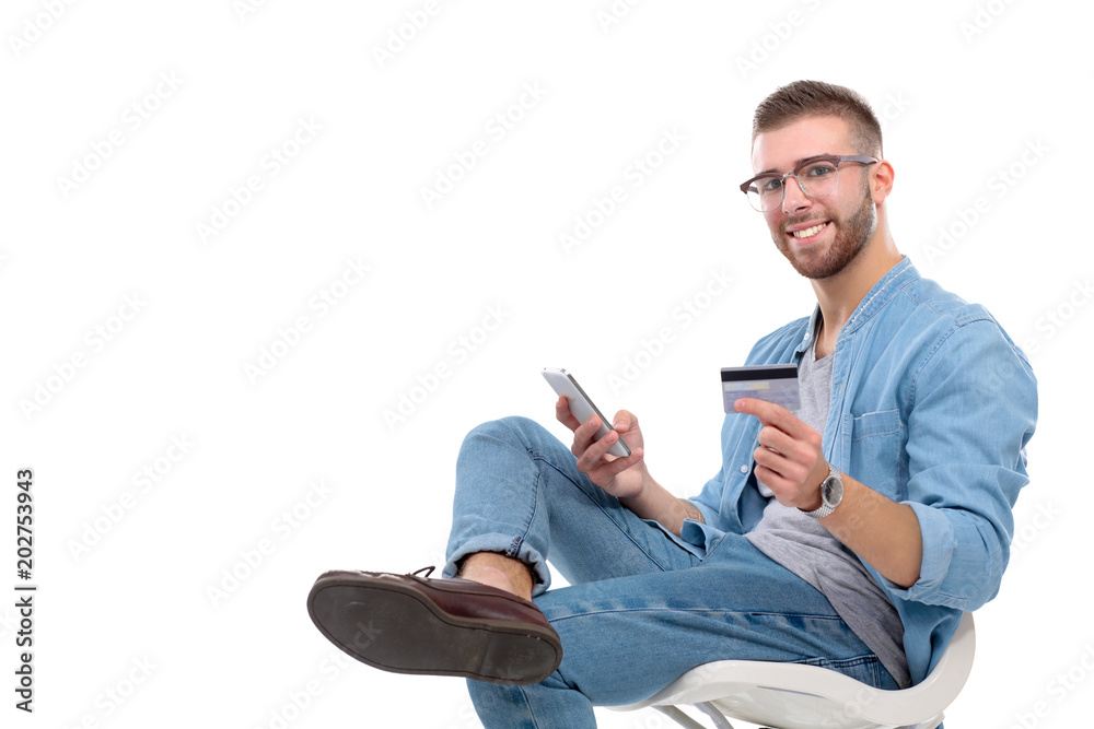 Young man sitting on chair and holding credit card. Startupper. Young entrepreneur. Young man sitting on chair and holding credit card. Startupper. Young entrepreneur.