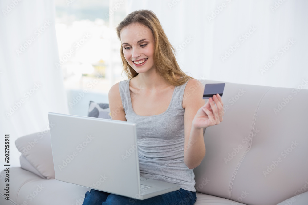 Young woman sitting on couch using laptop for online shopping Young woman sitting on couch using laptop for online shopping