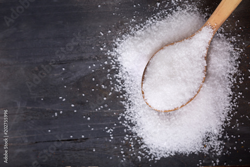 sea salt in a wooden spoon on wooden table