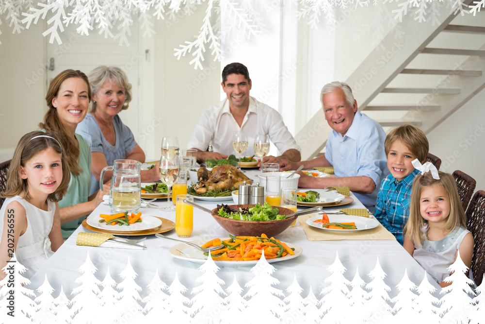 Family having meal together at dining table against fir tree forest and snowflakes