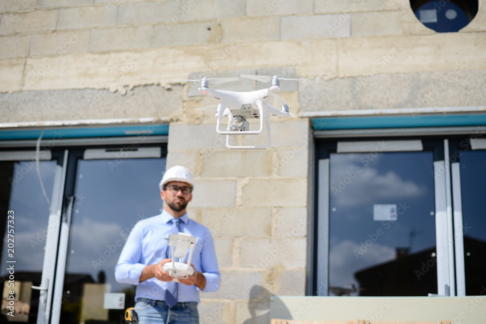 handsome architect flying inspection drone for aerial view of a house construction site industry handsome architect flying inspection drone for aerial view of a house construction site industry