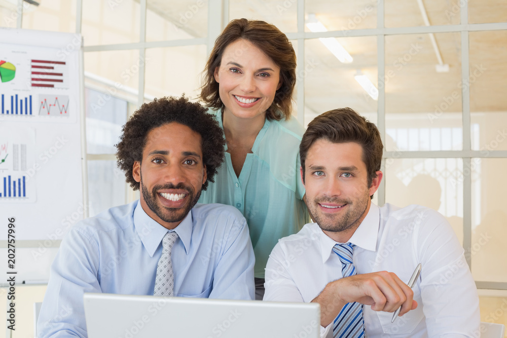 Smiling business people using laptop at office Smiling business people using laptop at office