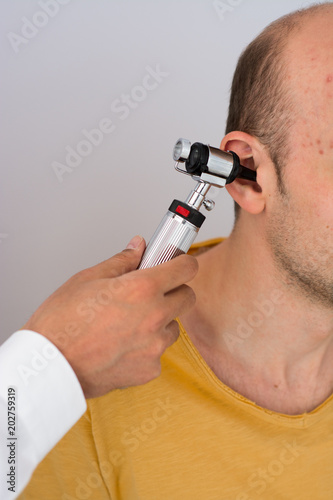 Doctor examining patients ear in doctors office