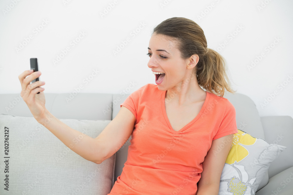 Surprised casual woman looking at her smartphone Surprised casual woman looking at her smartphone