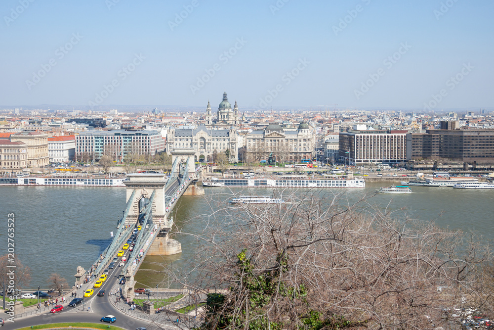 Fototapeta premium Aerial view of Budapest, with the Danube river, Szechenyi chain bridge, and Szent Istvan Basilica. Budapest is the capital city of Hungary and one of the main touristic destinations in the region