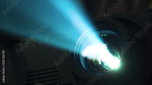 The projector shines with a blue beam in the dark