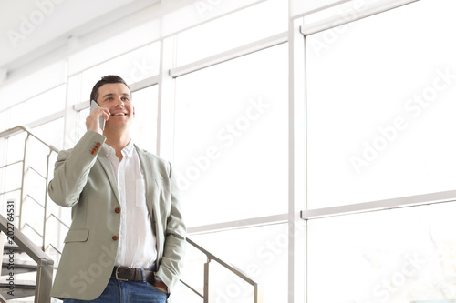 Portrait of confident businessman with mobile phone on stairs
