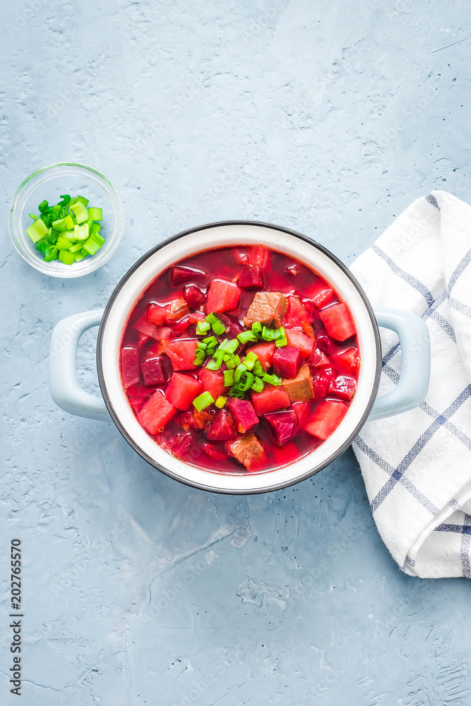 Classic beef borscht, traditional beetroot soup in pot on light blue,concrete background. Top view, space for text. Classic beef borscht, traditional beetroot soup in pot on light blue,concrete background. Top view, space for text.