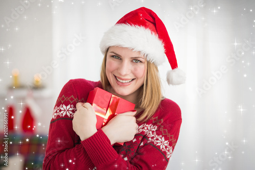 Festive pretty woman hugging her gift against twinkling stars