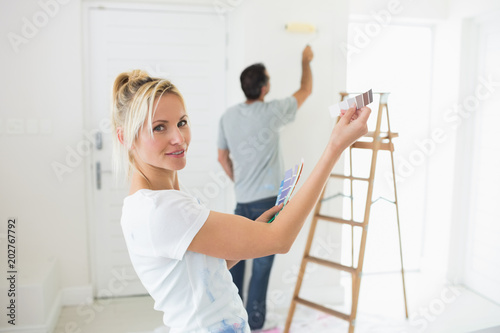 Couple with color swatches and ladder in a new house