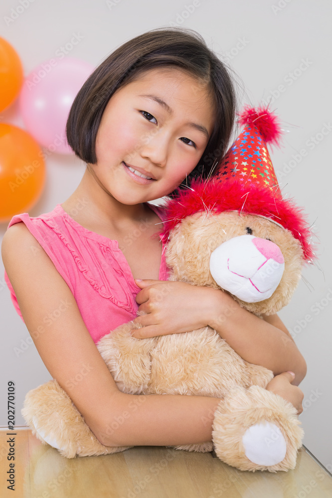 Cute little girl hugging soft toy at a birthday party Cute little girl hugging soft toy at a birthday party