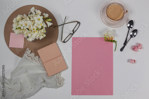 Cup of tea, spoons, spectacles, diary, cloth, blank page, paper balls and flowers © WavebreakmediaMicro